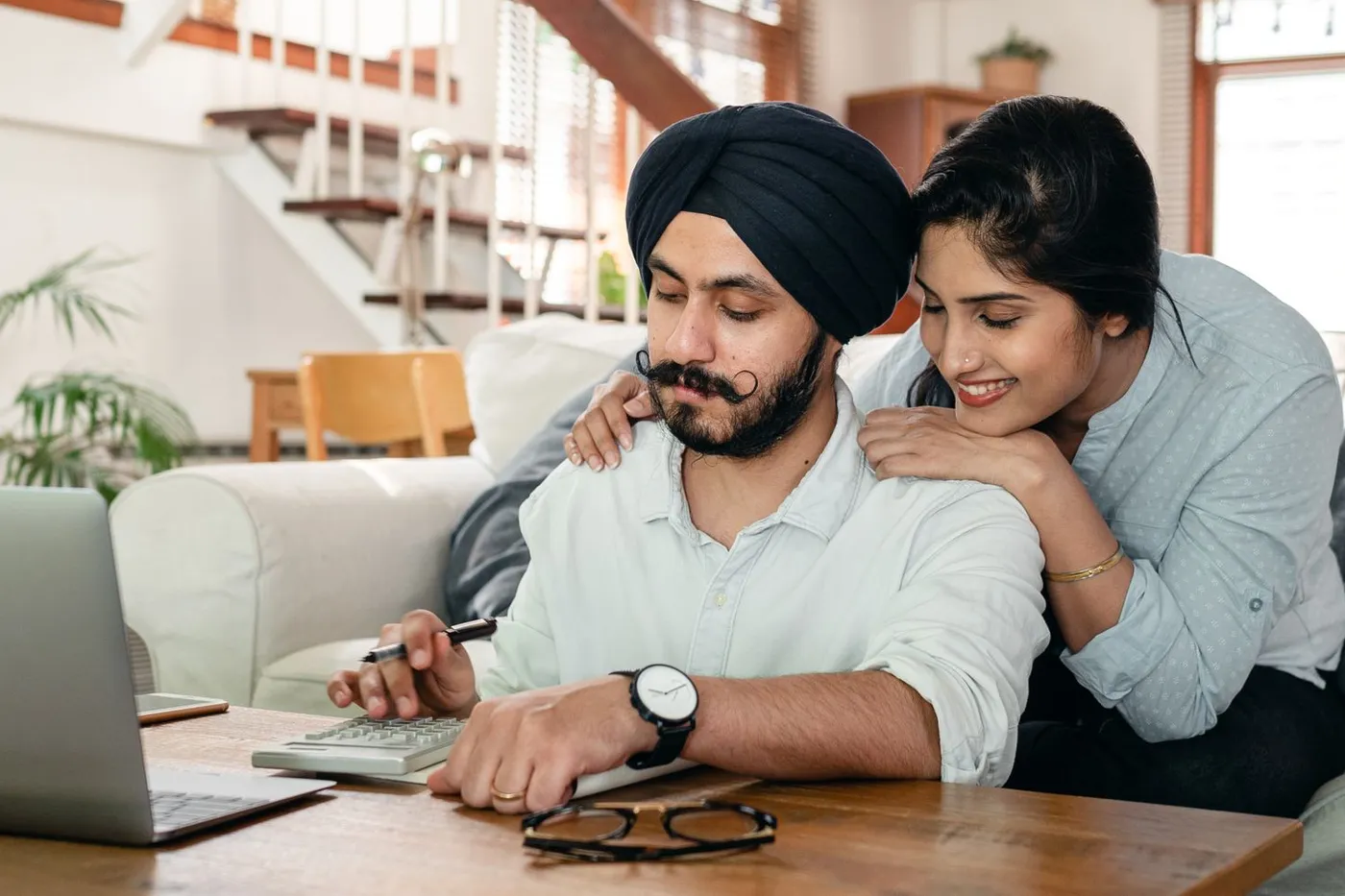 A couple at home working out costs with a calculator